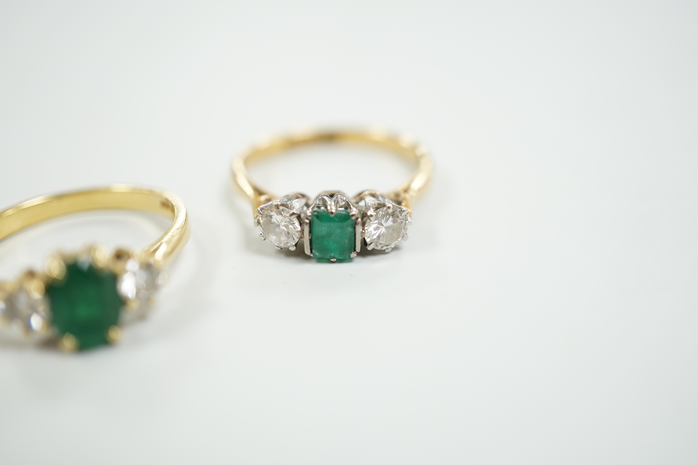 Two 18ct, single stone emerald and two stone diamond set rings, size M, gross weight, 5.5 grams.